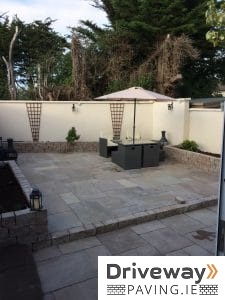 Indian sandstone patio on two levels with raised flower beds